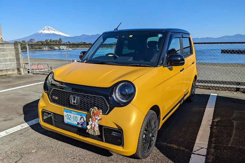 購入した自動車の写真。正月飾りをフロントにつけている。背景は富士山。